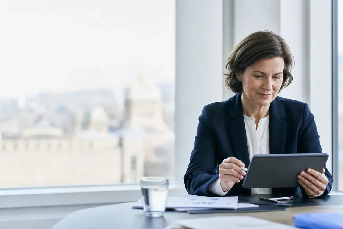 Une responsable consulte un rapport de santé publique sur sa tablette dans un bureau lumineux